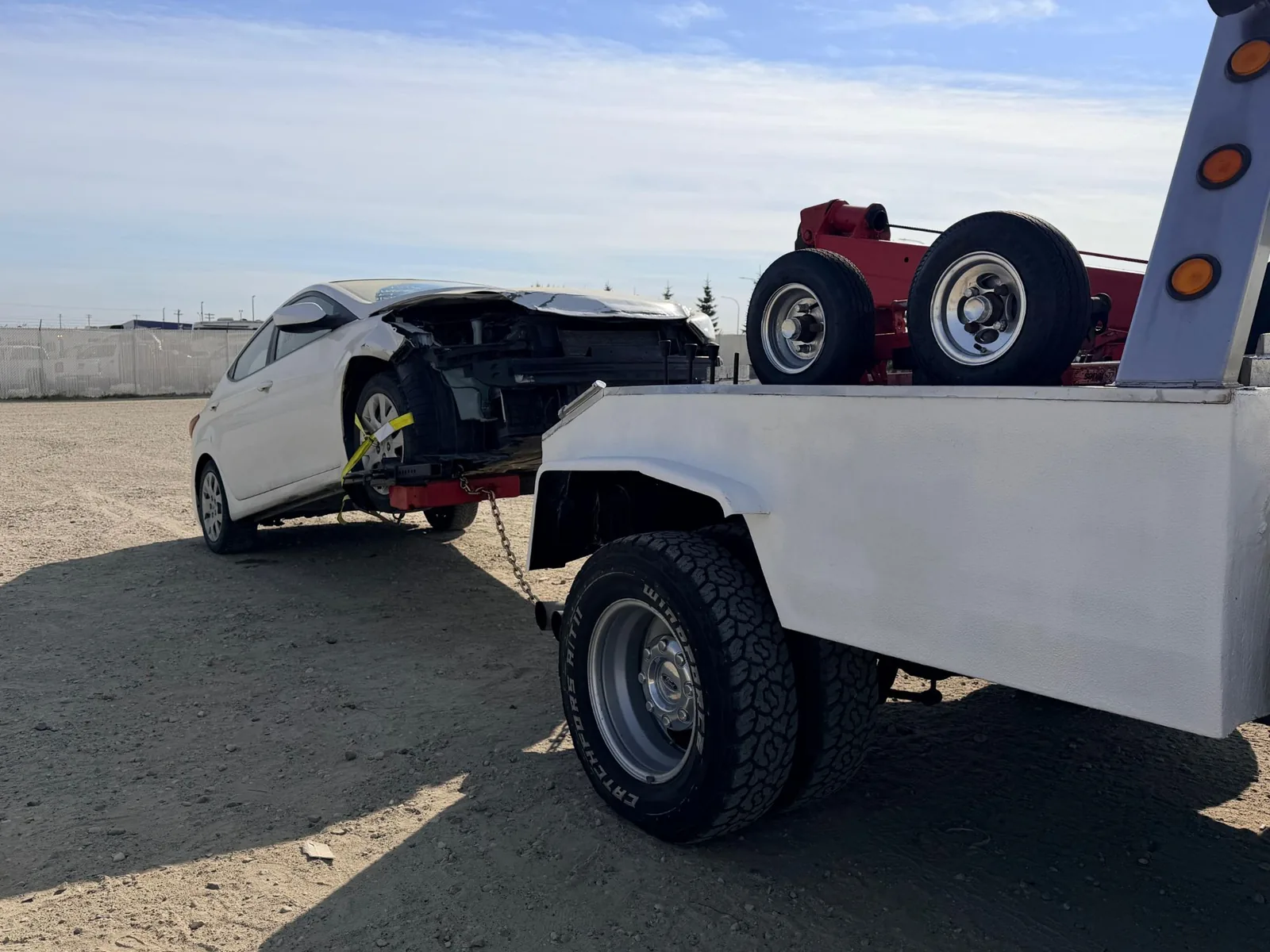 Front-end collision damaged Hyundai Elantra loaded on an Ironline tow truck in Edmonton