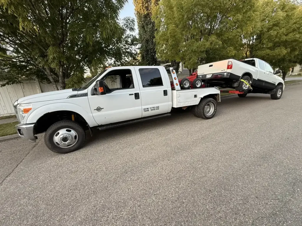 Ironline light duty tow truck towing a pickup truck in an Edmonton neighbourhood