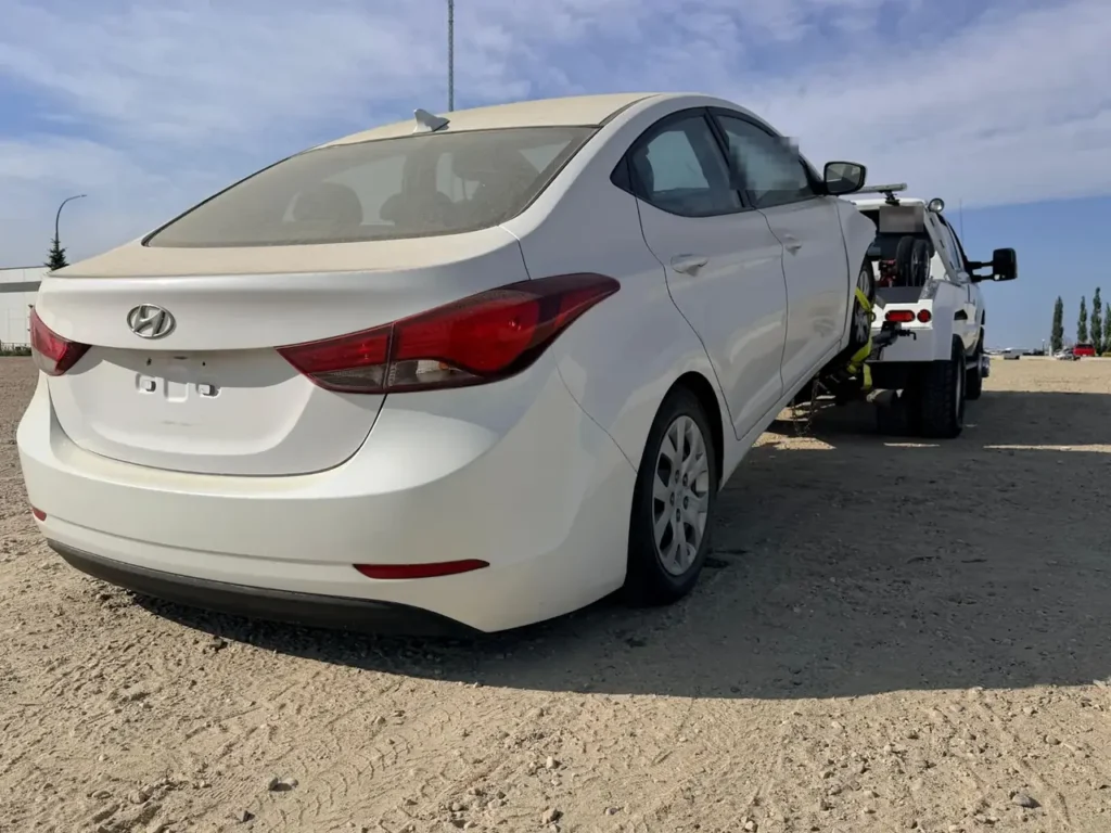 White Hyundai Elantra secured on an Ironline tow truck wheel lift in Edmonton